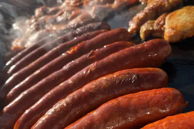 Klobásy a kuřecí maso na grilu při cateringu