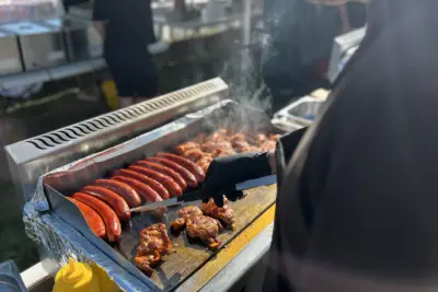 Grilování klobás a kuřecího masa na venkovní akci