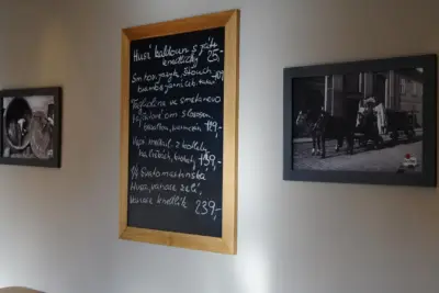 Tabule s nabídkou a obrazy na stěně