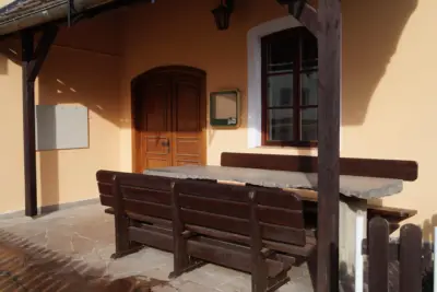 Vchod do restaurace s dřevěnou lavicí